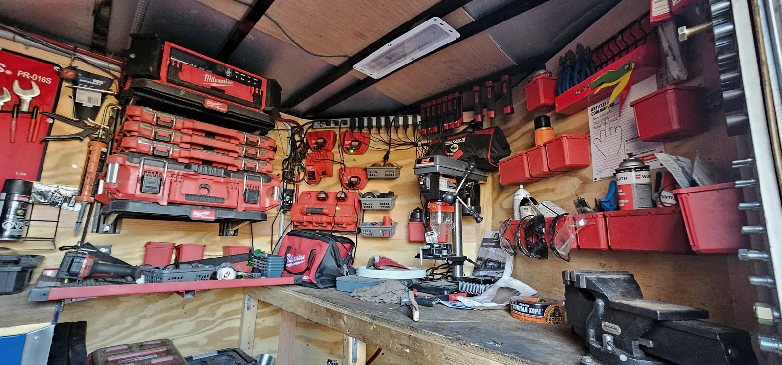 Intérieur de la remorque-atelier : établi, coffres à outils et rangements.